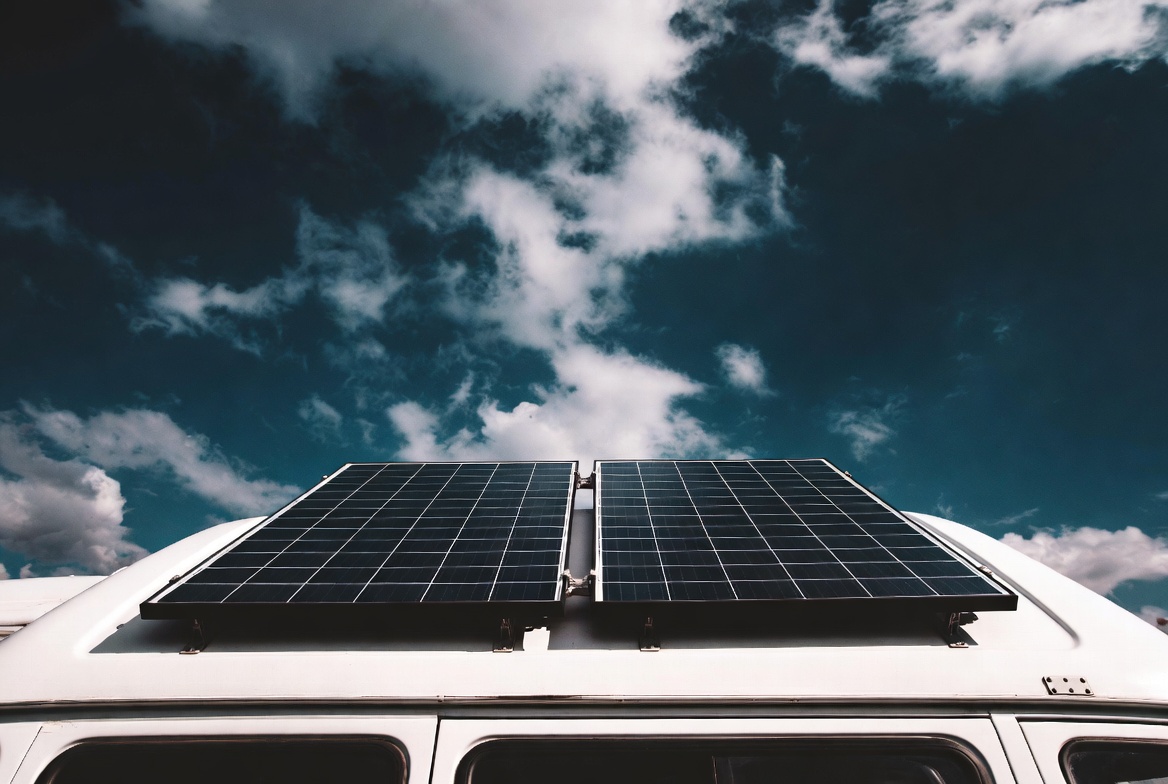Paneles solares monocristalinos montados en el techo de una furgoneta camper contra cielo dramático